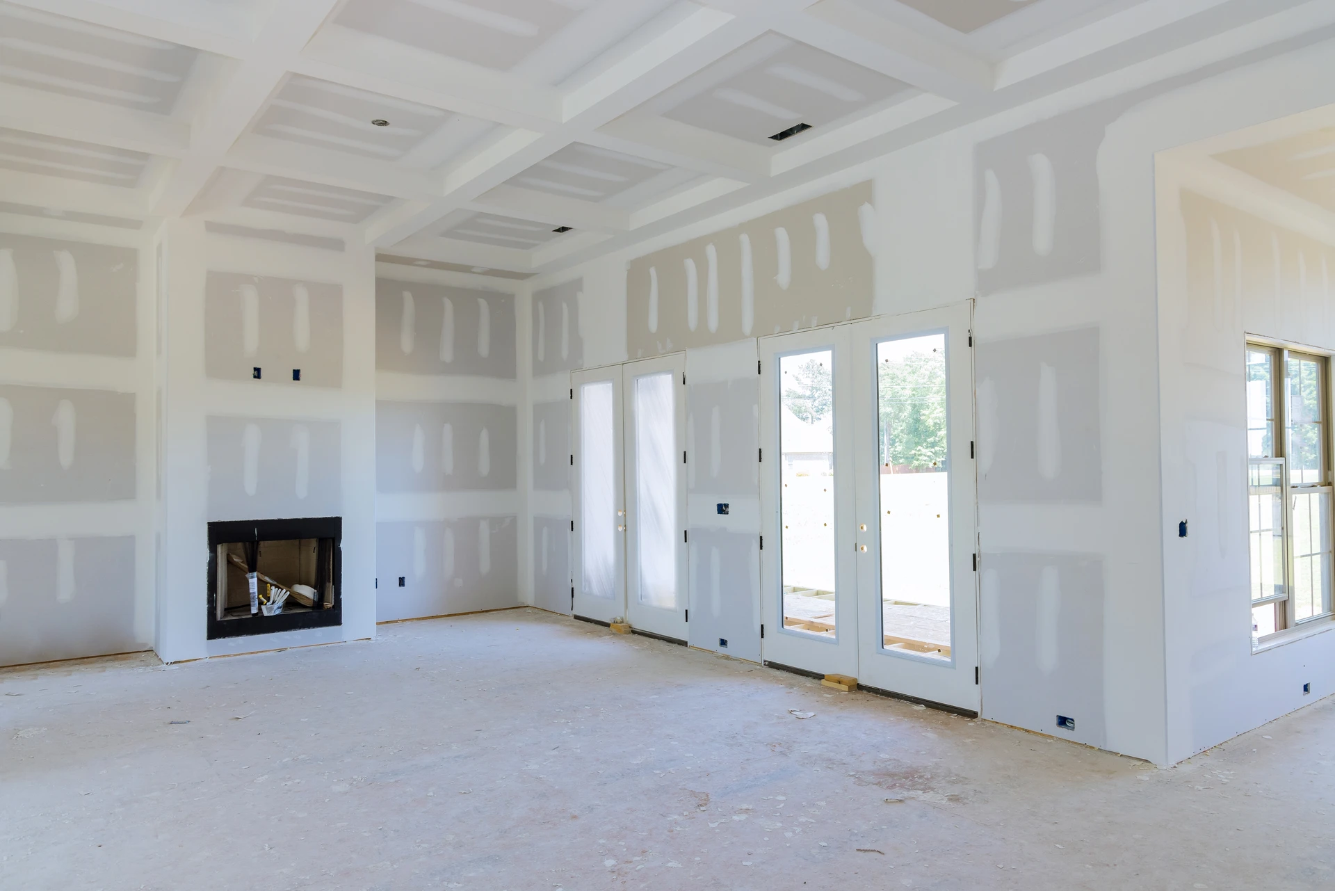 Intérieur de maison en cours de construction avec murs en plaques de plâtre non peintes, joints apparents